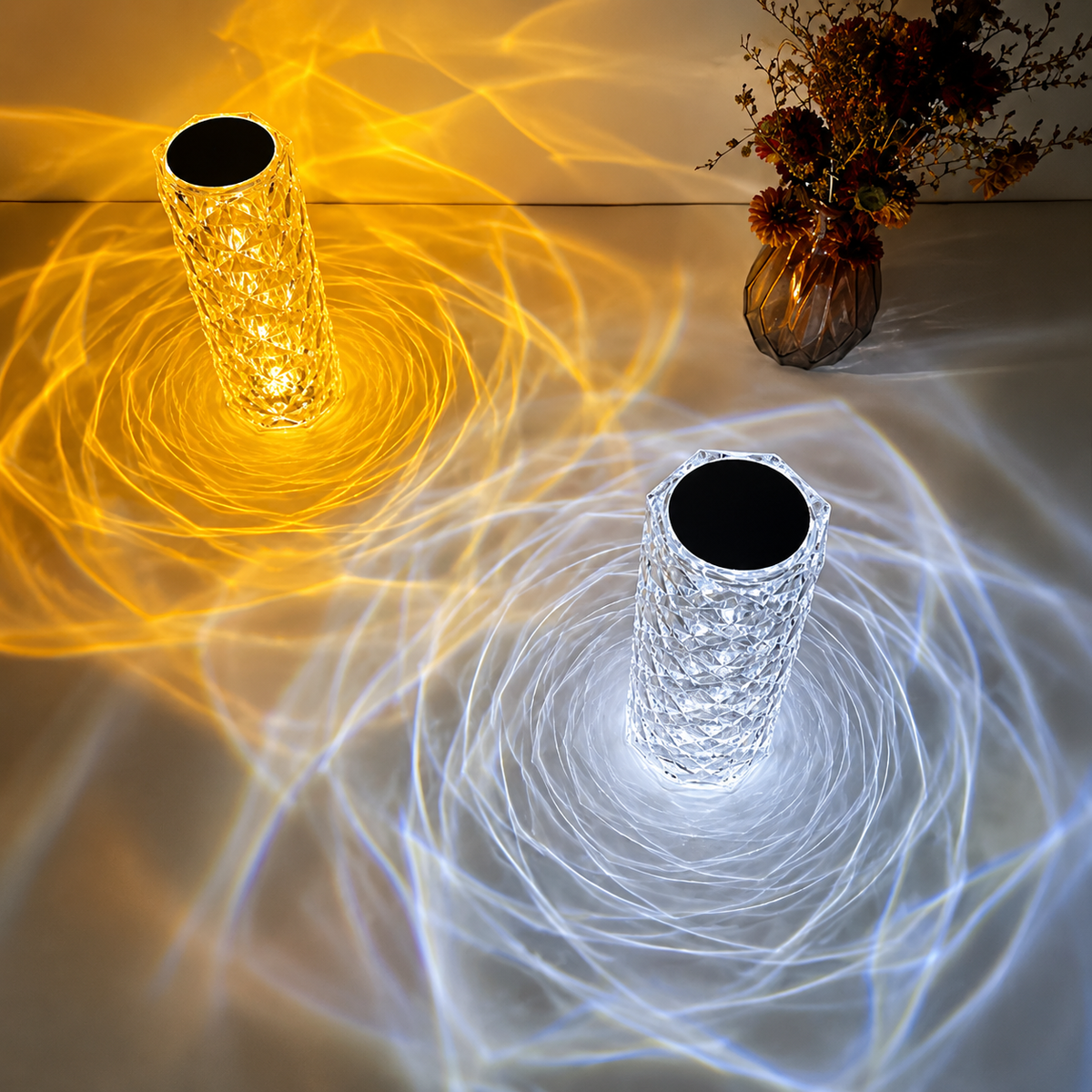 Two crystal LED table lamps projecting warm and cool light patterns